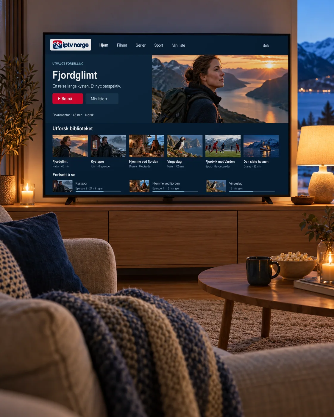 TV på en eikeskjenk i en stue med utsikt over fjorden i kveldslys